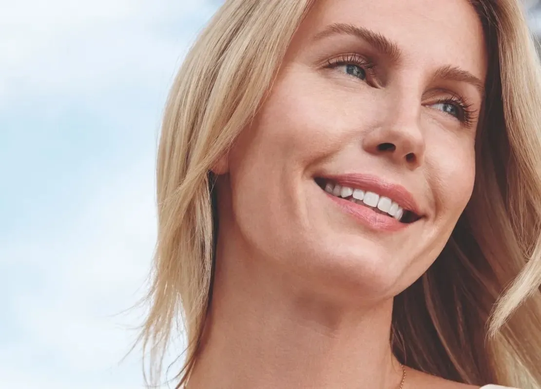 A woman with long blonde hair smiling for the camera.