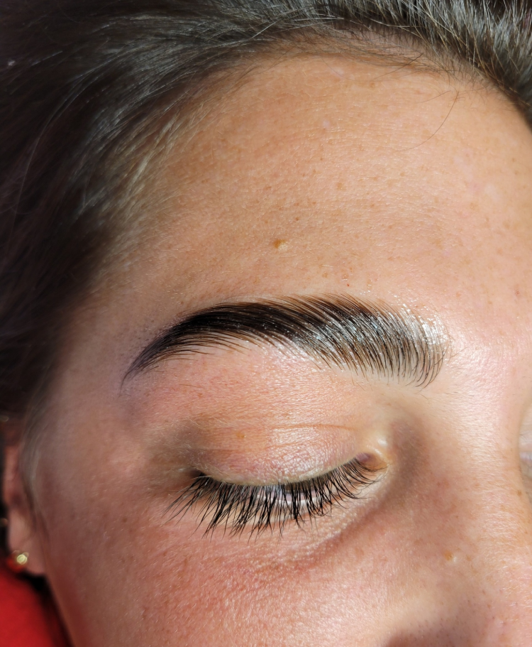 A woman with her eyes closed and brows drawn.