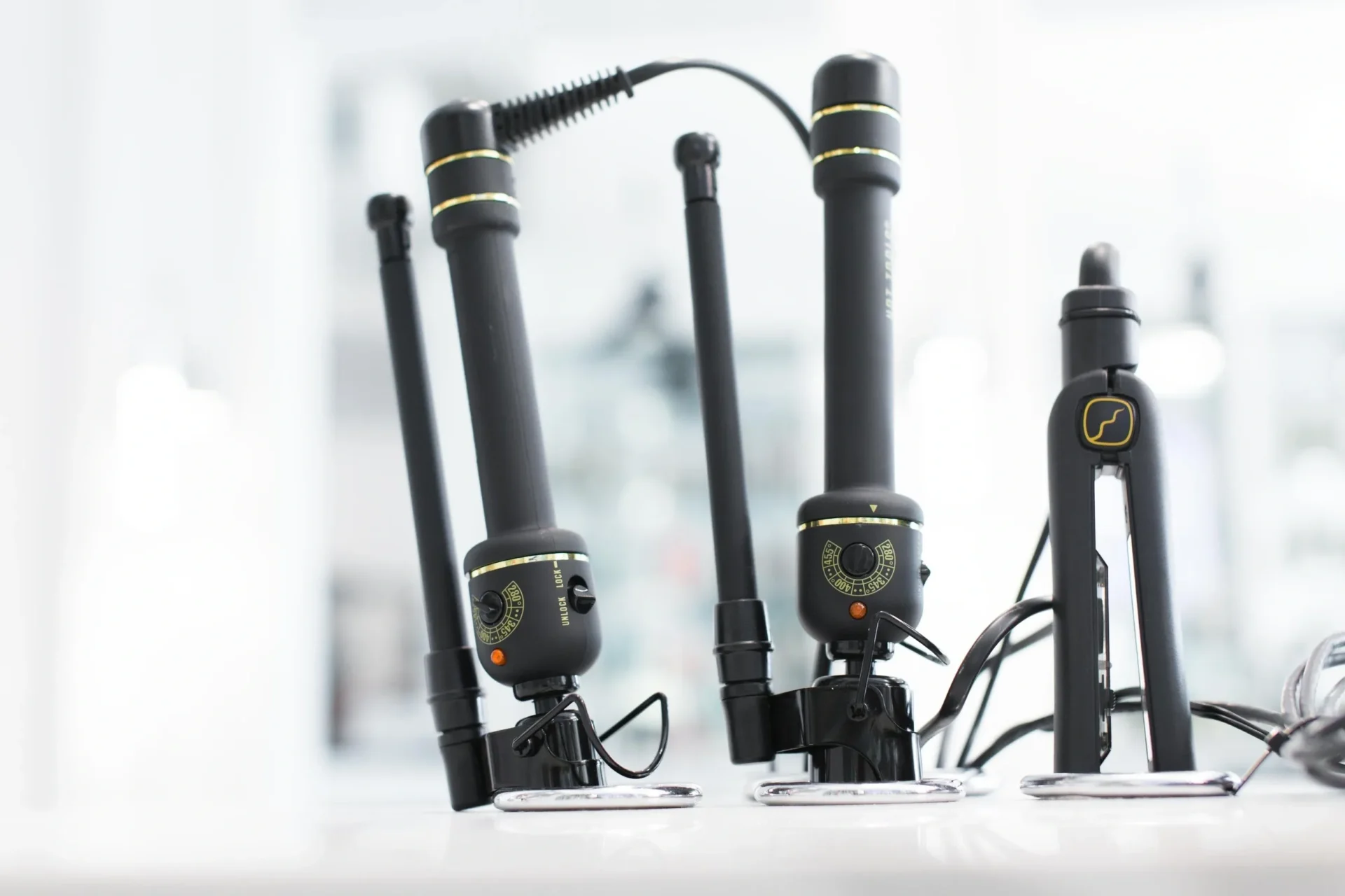 A group of four black and yellow hair dryers.