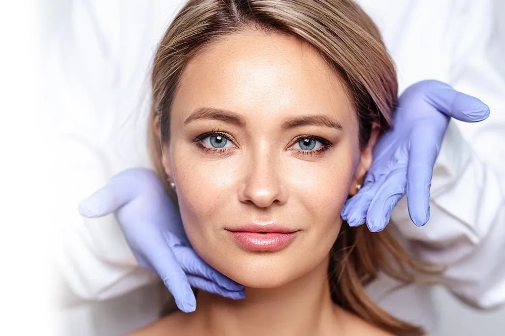 A woman with blue gloves on her head and face.