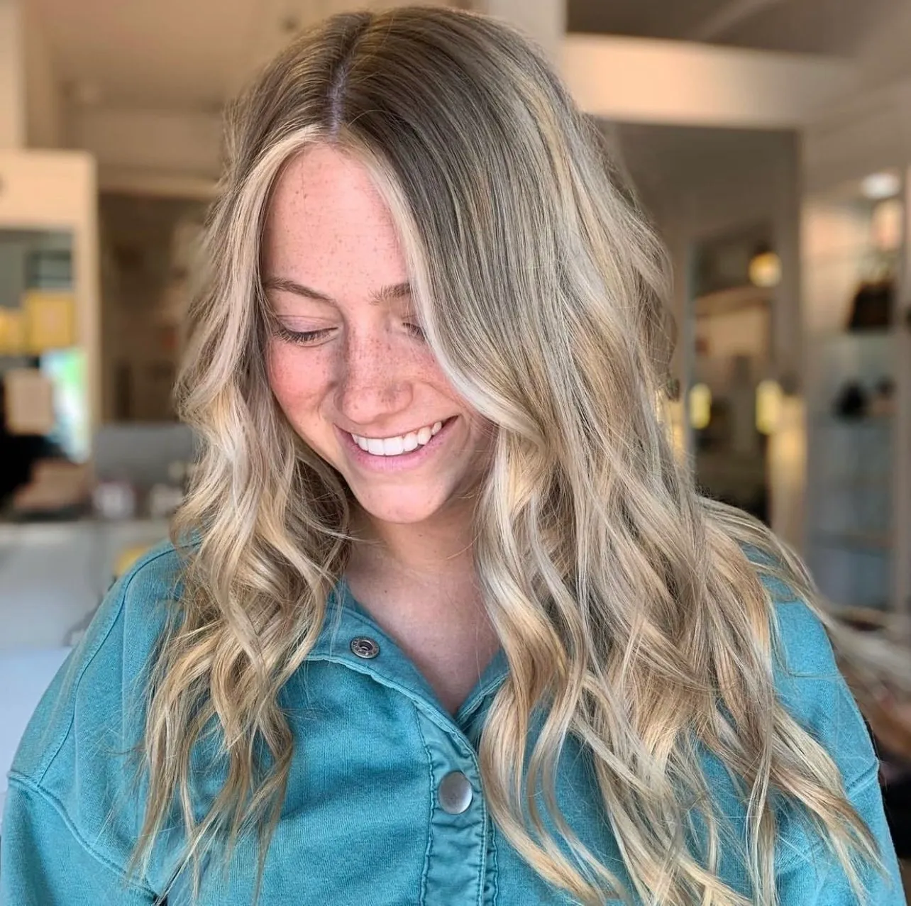 A woman with long blonde hair smiles at the camera.