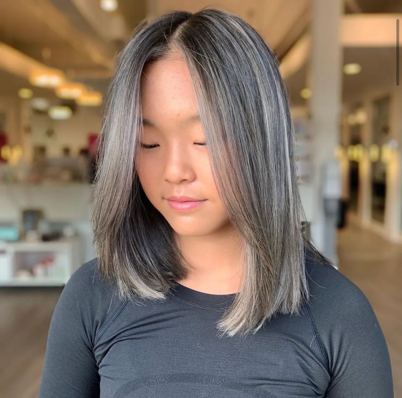 A woman with long hair is looking down.