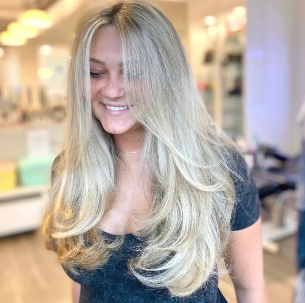 A woman with long blonde hair smiling at the camera.