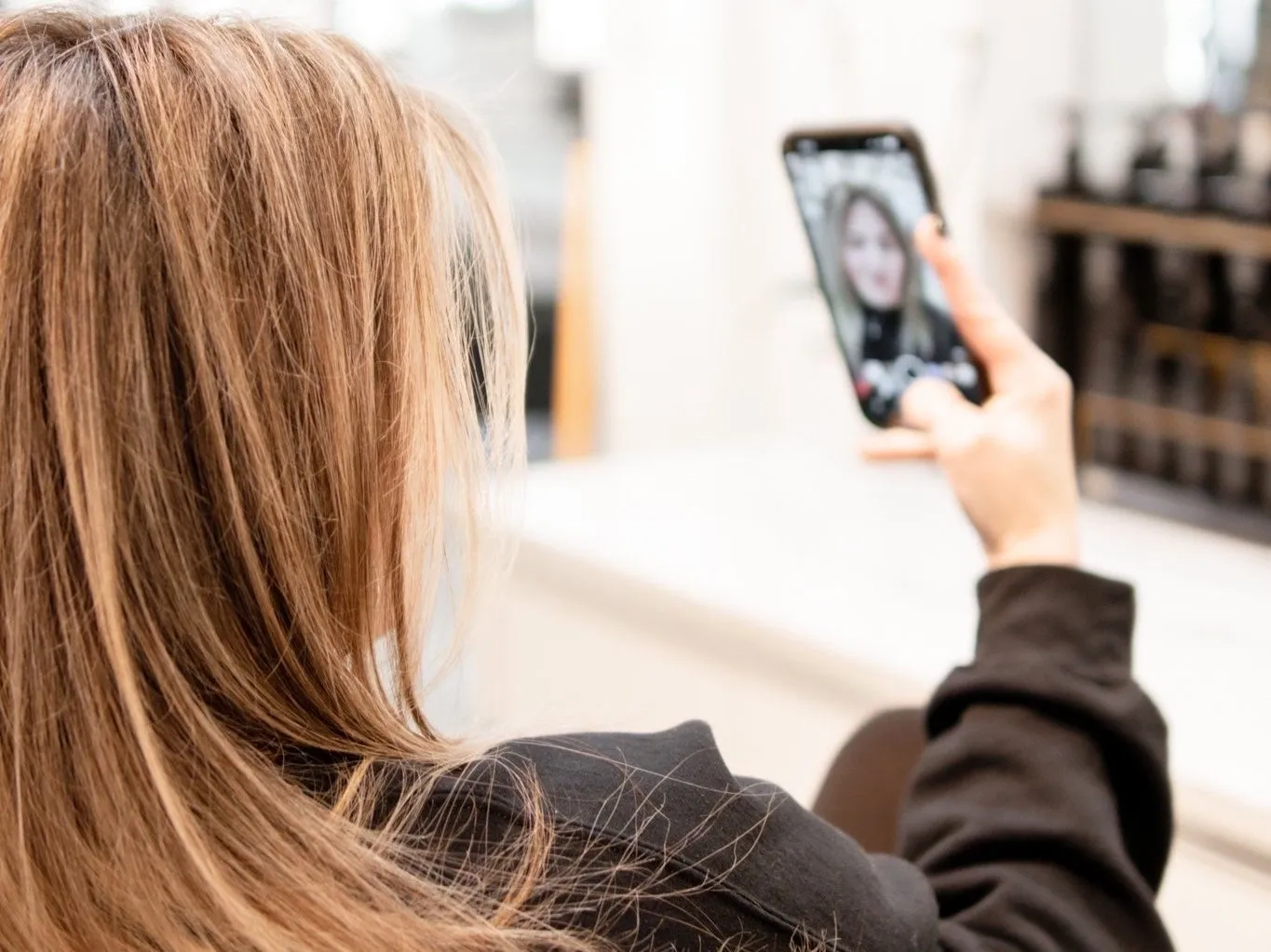 A woman is taking a picture of herself on her phone.