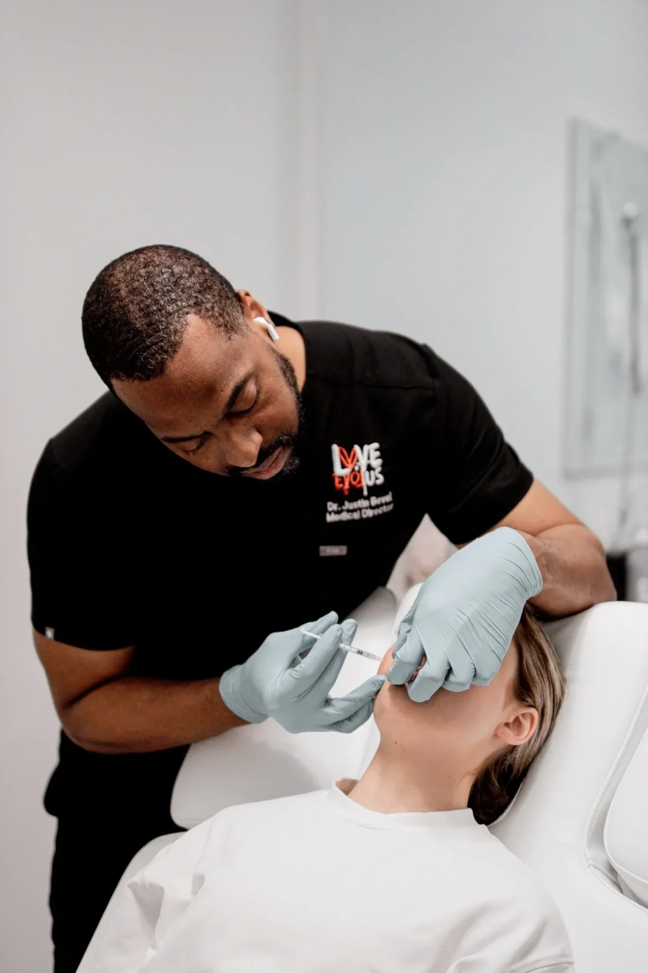 A man is getting his face waxed by another person.