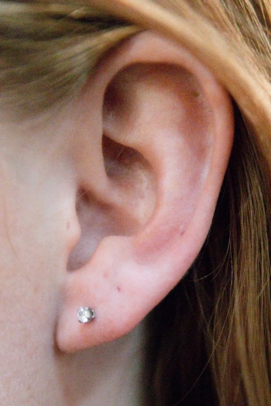 A close up of the ear with a small earring