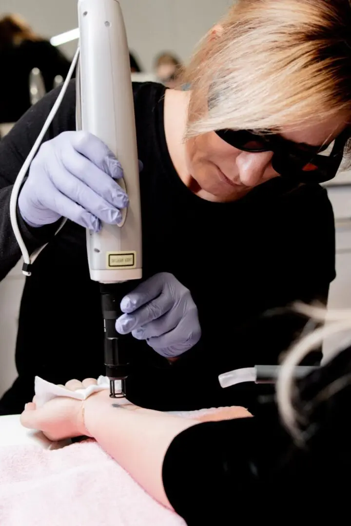 A woman is using an electric device to straighten her hair.