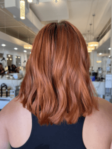 A woman with red hair is looking at the mirror.