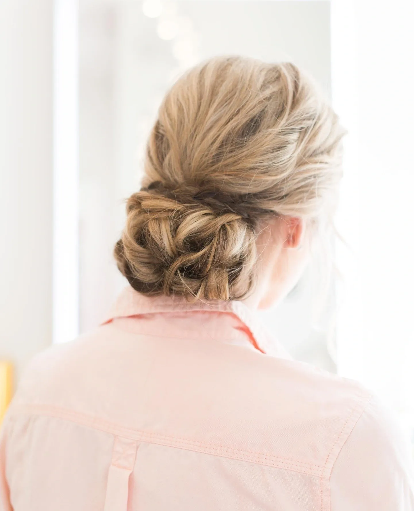 A woman with blonde hair is wearing pink.