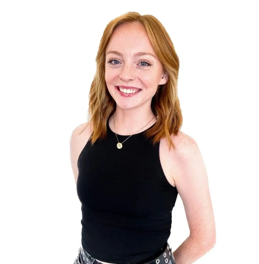 A woman in black shirt and jeans smiling for the camera.