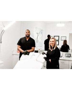 Two people standing in a room with some mirrors