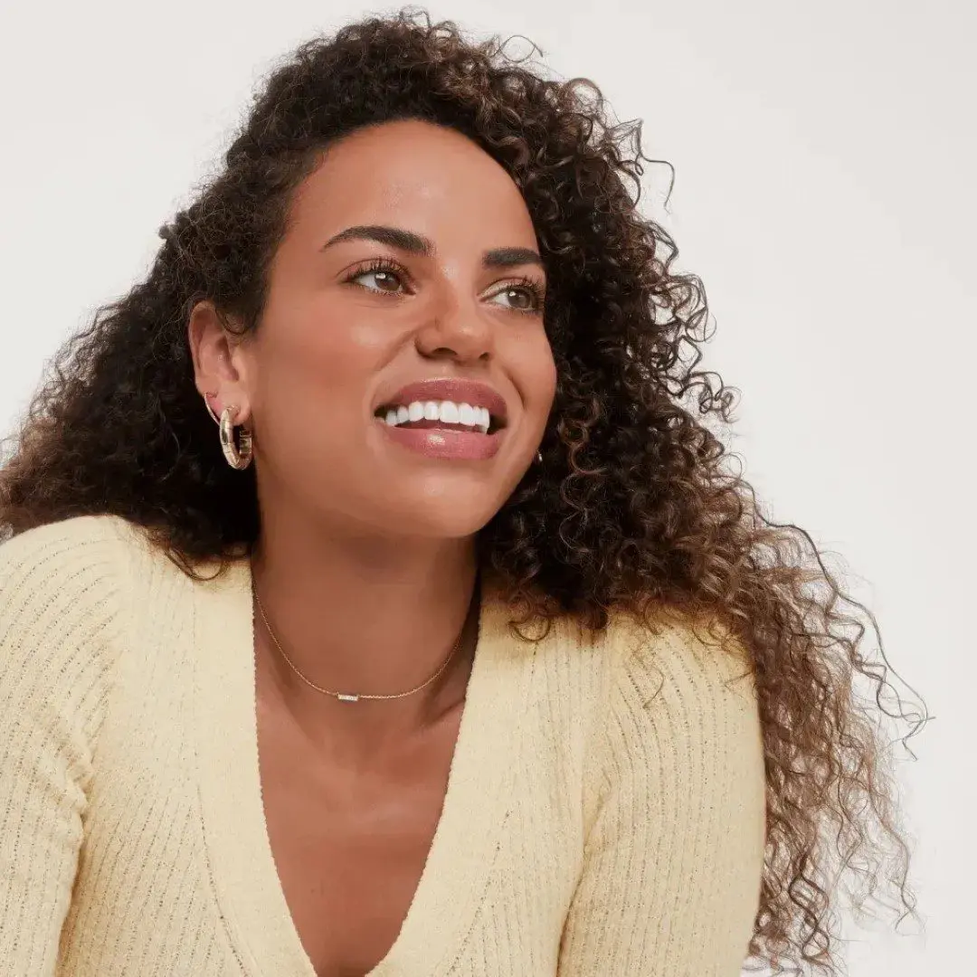 A woman with long hair is smiling for the camera.