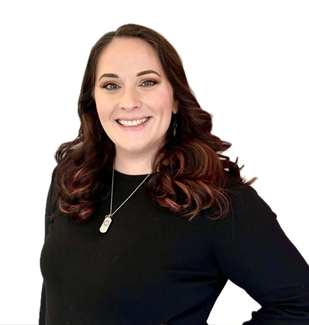 A woman with long hair wearing black is smiling.