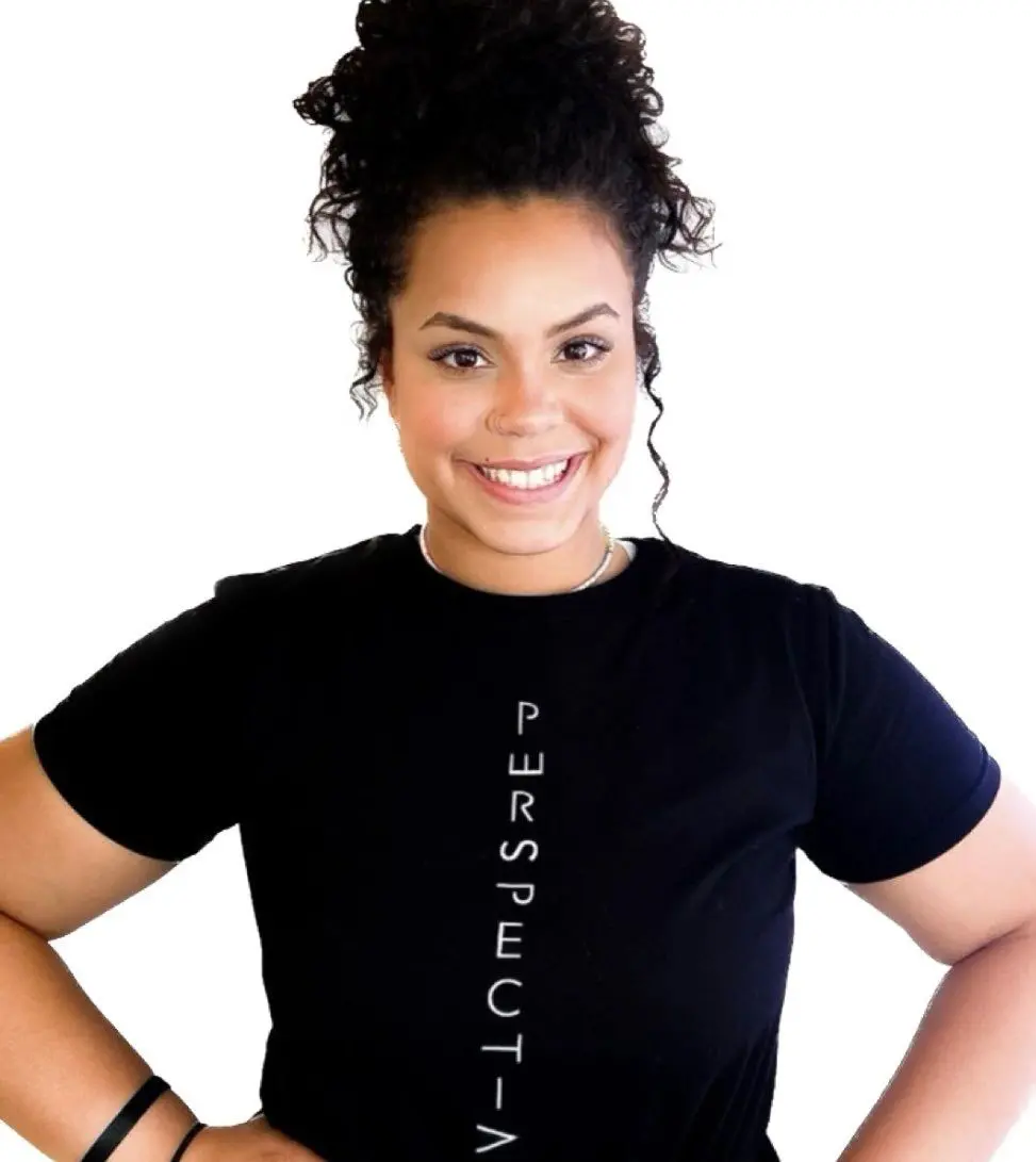 A woman in black shirt standing with her hands on hips.