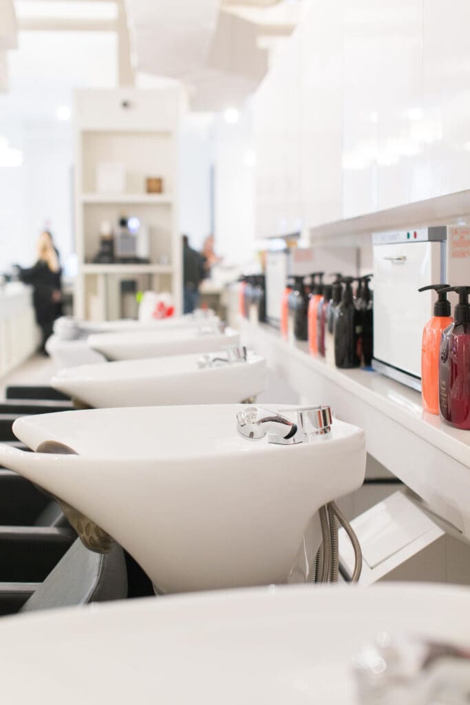 A row of hair salon chairs in front of the counter.