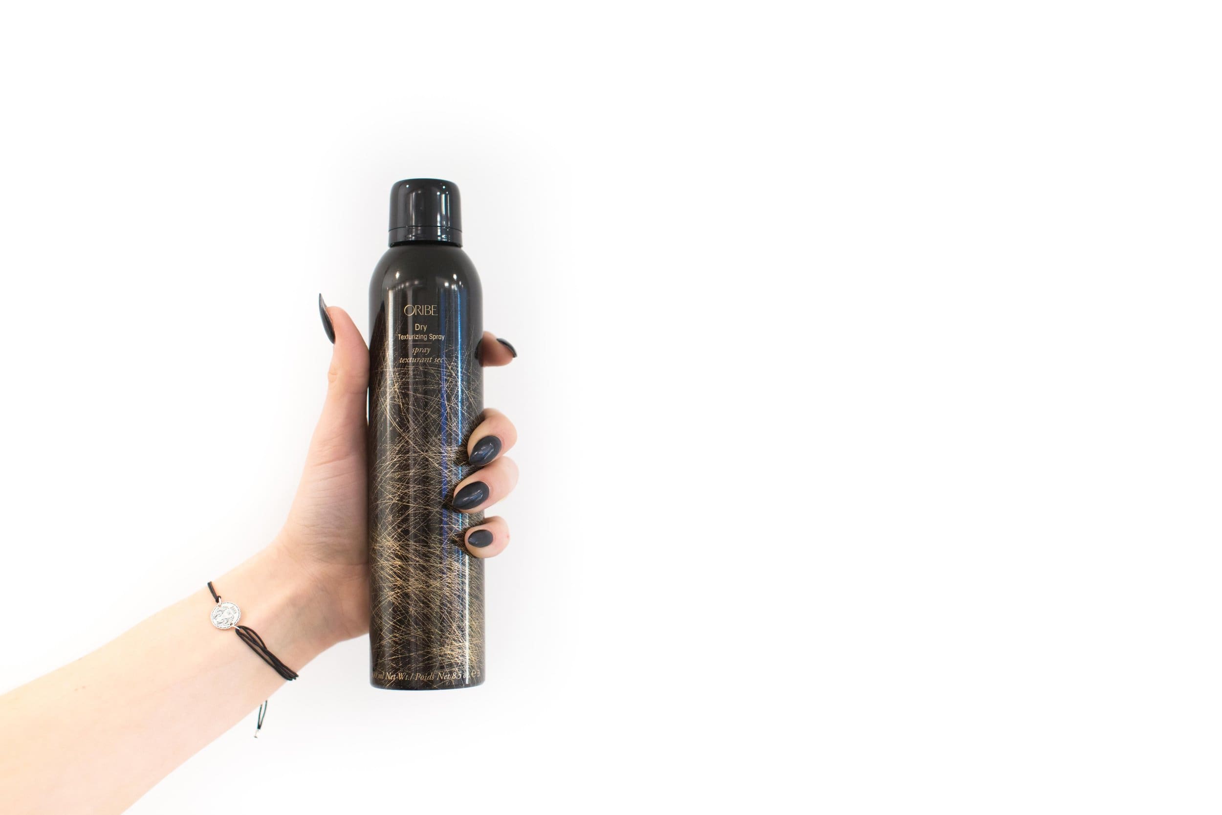 A person holding a bottle of hair spray.