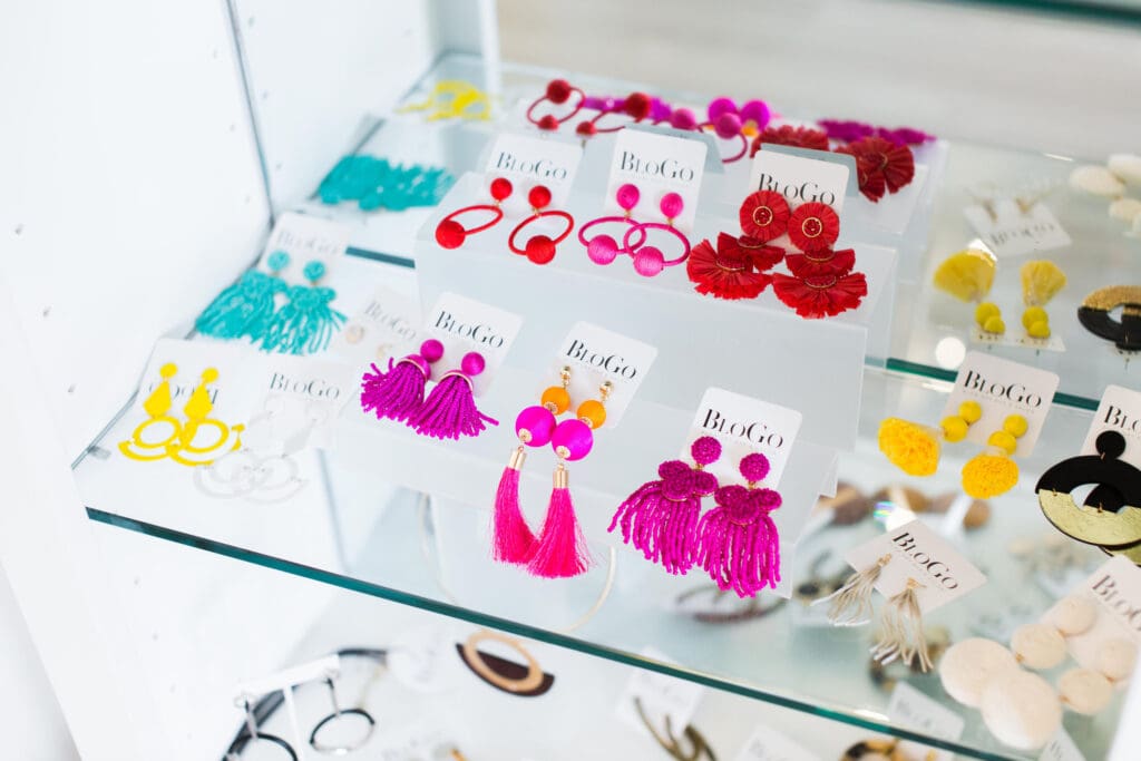 A glass table with many different types of earrings.