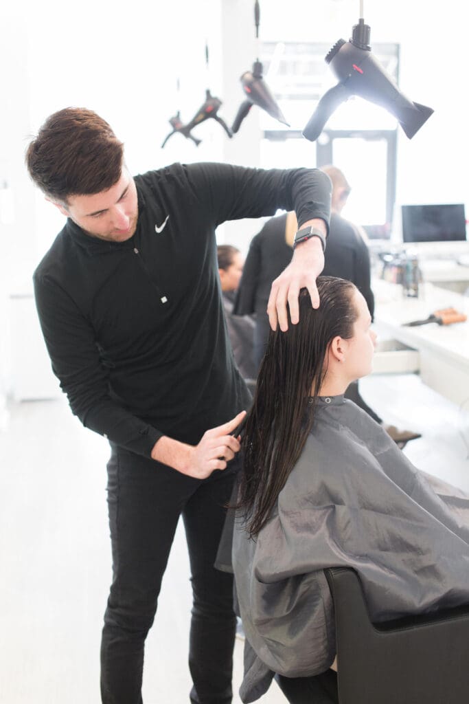 A man is cutting the hair of another person.