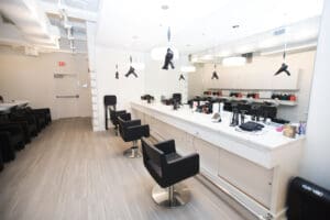 A hair salon with black chairs and white counters.