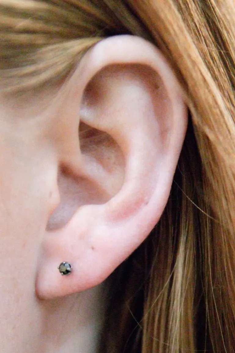 A close up of the ear with a piercing