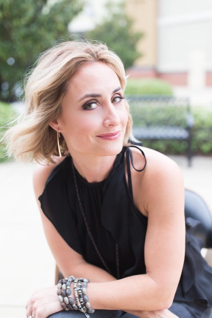 A woman sitting on the ground wearing black.