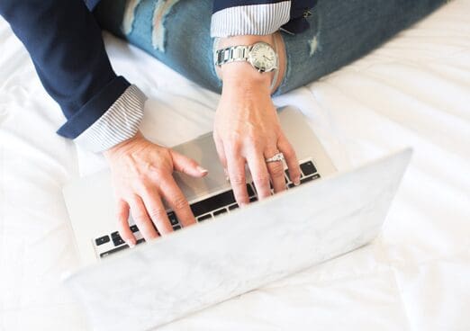 A person is using a laptop on the bed