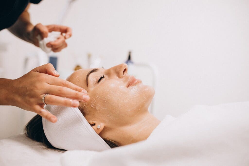 A woman getting her face washed by a person.