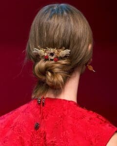 A woman with long hair in a bun.