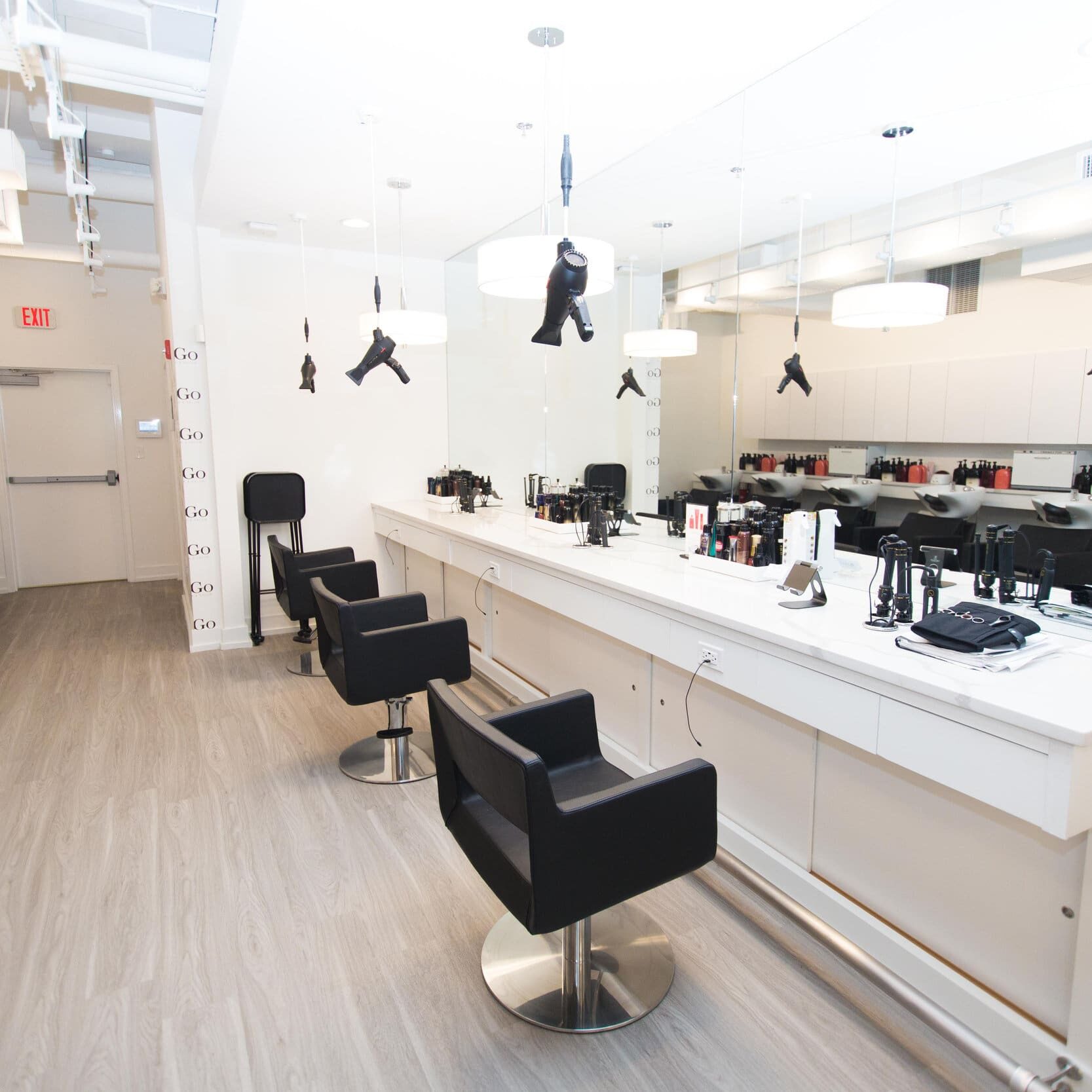 A hair salon with black chairs and white counters.