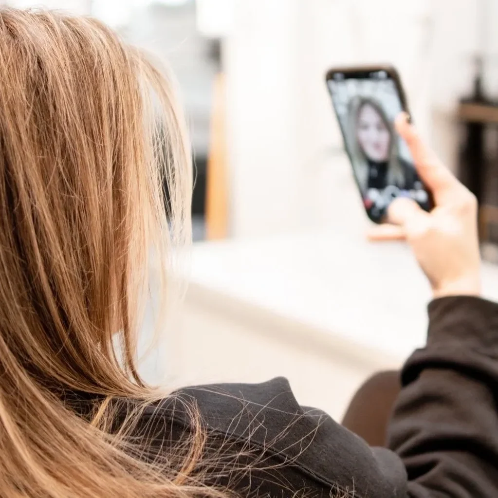 A woman is taking a picture of herself on her phone.