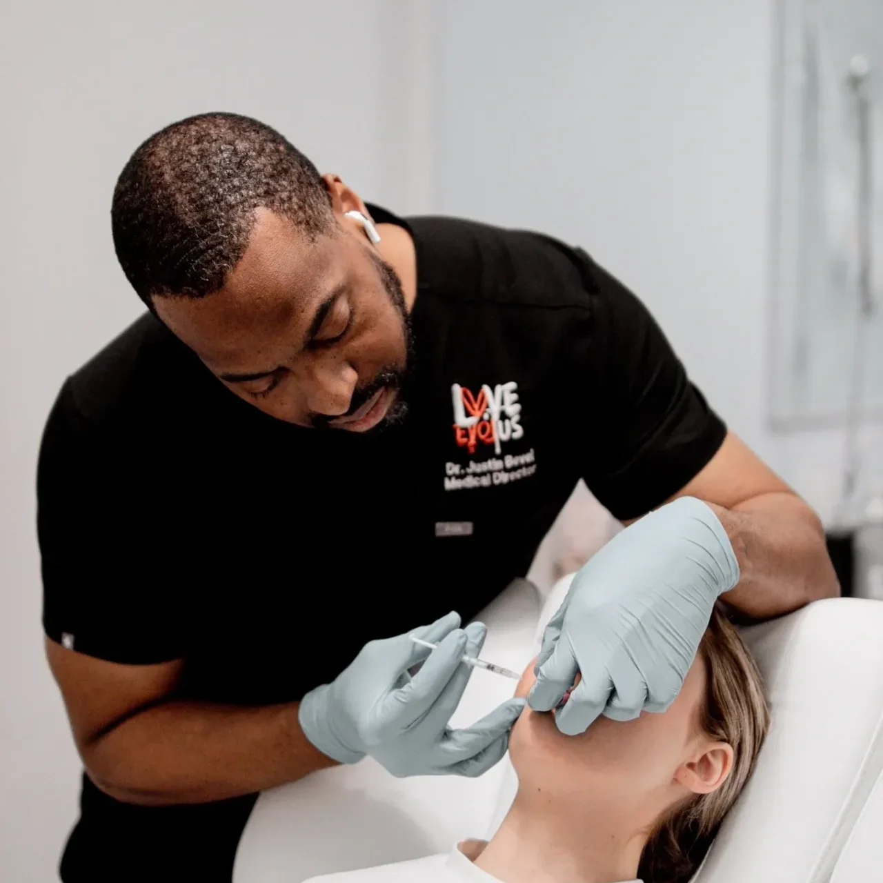 A man is getting his face waxed by another person.