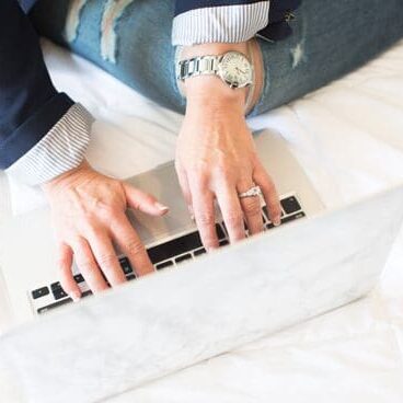 A person is using a laptop on the bed